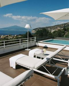 a balcony with a table and a swimming pool at Villa Oriana Relais in Sorrento