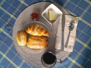 a plate of bread and butter and a cup of coffee at Résidence Belle Place Palmier in Saint-François