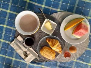 a table with plates of bread and a cup of coffee at Résidence Belle Place Palmier in Saint-François