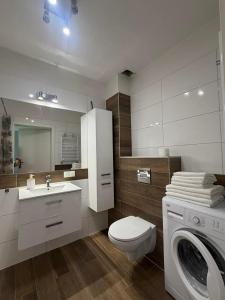 a bathroom with a toilet sink and a washing machine at Apartament Marco z balkonem in Oleśnica +15 photos