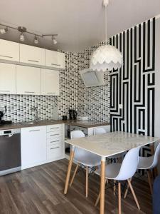 a kitchen with white cabinets and a table and chairs at Apartament Marco z balkonem in Oleśnica