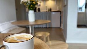 Eine Tasse Kaffee steht auf einem Tisch. in der Unterkunft Æ Quinta in Klitmøller