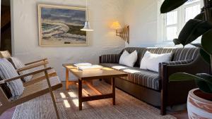 ein Wohnzimmer mit Sofa und Tisch in der Unterkunft Æ Quinta in Klitmøller