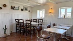 ein Restaurant mit Tischen und Stühlen in einem Raum in der Unterkunft Æ Quinta in Klitmøller + 6 Fotos