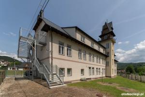 a building with a windmill on the side of it at Pokoje u Strażaka in Krościenko