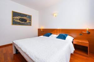 a bedroom with a large white bed with blue pillows at Hotel New Genziana in Altavilla Vicentina