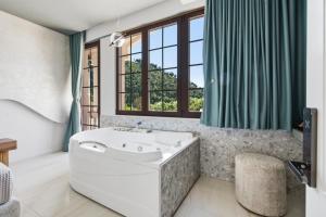 a bathroom with a tub and a large window at Art Boutique Hotel Berat in Berat +100 photos