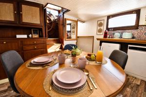 a wooden table with plates and utensils in a kitchen at Péniche Le Makara in Avignon