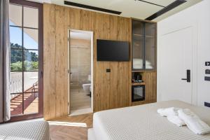 a bedroom with a bed and a television on a wall at Art Boutique Hotel Berat in Berat