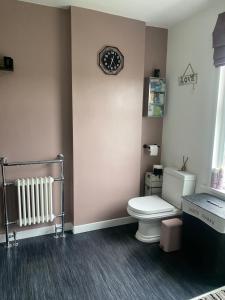 a bathroom with a toilet and a clock on the wall at Butterfly House in Blackwood +46 photos