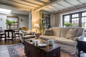 a living room with a couch and a table at Apple Cottage in Snowshill