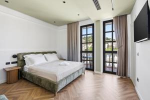 a bedroom with a bed and two windows at Art Boutique Hotel Berat in Berat