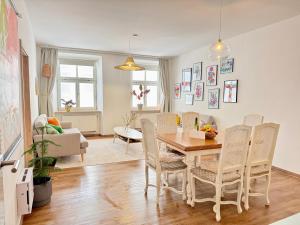 a dining room and living room with a table and chairs at 2 Unique Apartments in the Historic Center in Straubing