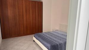 a bedroom with a bed and a wooden cabinet at Casa Narciso, semi-detached cottage in Marina di Massa
