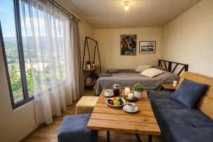 a living room with a table and a bed at TEVRA Nature, Retreat Mountain Cabins Above the City Ijevan, Dilijan in Ijevan