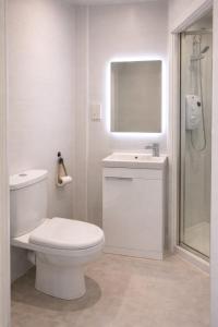 a white bathroom with a toilet and a sink at Station Hotel in Burghead