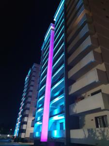 a tall building with purple and blue lights on it at Blue Apartment with Free Parking&Self Check-in in Bistriţa +2 photos
