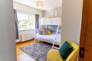 a bedroom with a bunk bed and a yellow chair at Foxhill - Valentia in Valentia Island