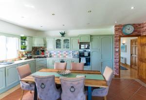 a kitchen with a wooden table and chairs at Foxhill - Valentia in Valentia Island