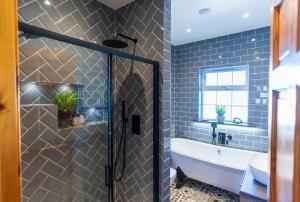 a bathroom with a tub and a sink at Foxhill - Valentia in Valentia Island +28 photos