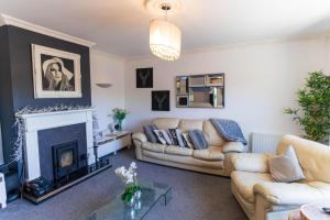 a living room with two couches and a fireplace at Foxhill - Valentia in Valentia Island