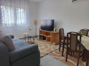 a living room with a couch and a table and a tv at Apartman Kutak in Pirot