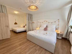 a bedroom with two beds with white sheets and pink pillows at 2 Unique Apartments in the Historic Center in Straubing