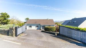 a white house with a fence and a driveway at Foxhill - Valentia in Valentia Island