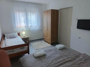 a bedroom with a bed and a dresser and a television at Apartman Kutak in Pirot