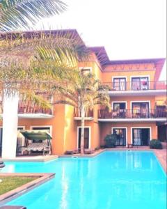 a swimming pool in front of a house at Petit Charlie @ Forest view in Banjul