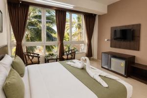 a bedroom with a bed with white towels on it at Hotel L ! M Calangute Beach Way in Calangute