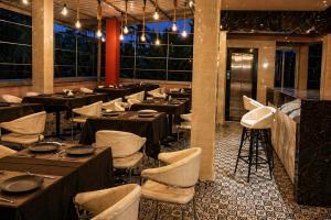 a restaurant with tables and chairs in a room at Hotel L ! M Calangute Beach Way in Calangute