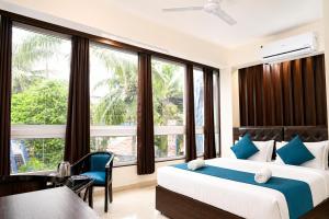 a bedroom with a bed and a large window at Hotel L ! M Calangute Beach Way in Calangute