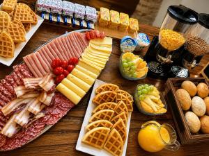 a table topped with different types of meats and waffles at Boutique Rooms Malo More - Old Town and Parking in Trogir