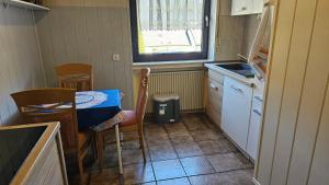 a small kitchen with a table and chairs and a window at Apartment Wildgrund in Siegen +9 photos