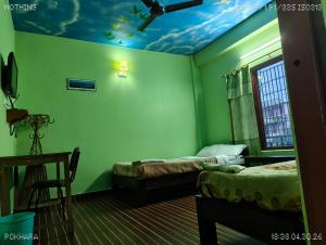 a room with two beds and a ceiling with a painting on it at Harry Guest House & Restaurant in Pokhara +90 photos