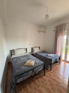 a bedroom with two beds and a window at Margaret's Guest House in Mesopotam