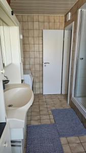a bathroom with a white sink and a white door at Apartment Wildgrund in Siegen