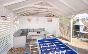 a living room with a ping pong table and a couch at Domki Maks in Bobolin