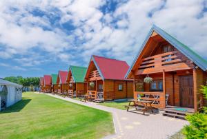 a row of wooden cabins in a row at Domki Maks in Bobolin