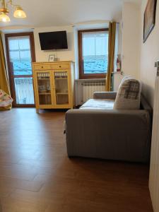 a living room with a couch and a tv at Centro - La Tana di Nico & Chri in Bardonecchia