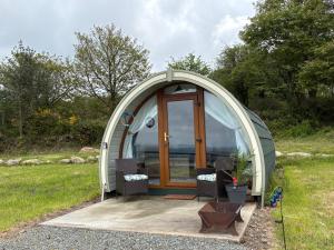 a dome tent in a field with two chairs at Kingsford Pod in Wexford