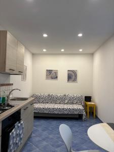 a kitchen with a couch in the corner of a room at Fefalù House in Ischia Town