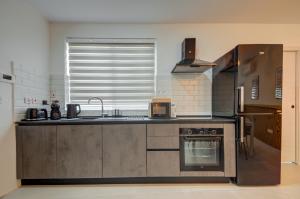 a kitchen with a sink and a stove at The Oasis - R4 in Senglea