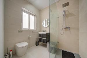 a bathroom with a toilet and a glass shower at The Oasis - R4 in Senglea