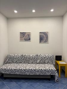 a couch in a room with three pictures on the wall at Fefalù House in Ischia Town