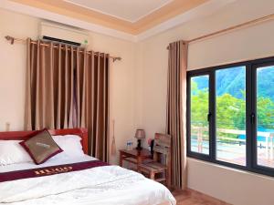 a bedroom with a bed and a large window at Applebee's Homestay in Phong Nha
