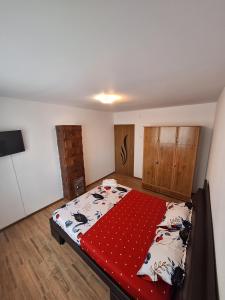 a bedroom with a large bed with a red blanket at L.M. in Sulina