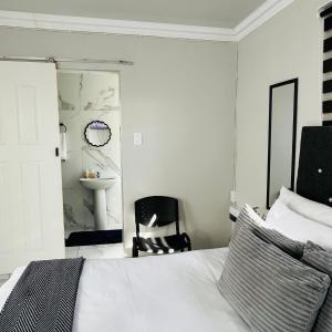 a bedroom with a bed and a chair and a sink at 4 at Granada 1 in East London