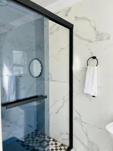 a glass shower door in a bathroom with a sink at 4 at Granada 1 in East London